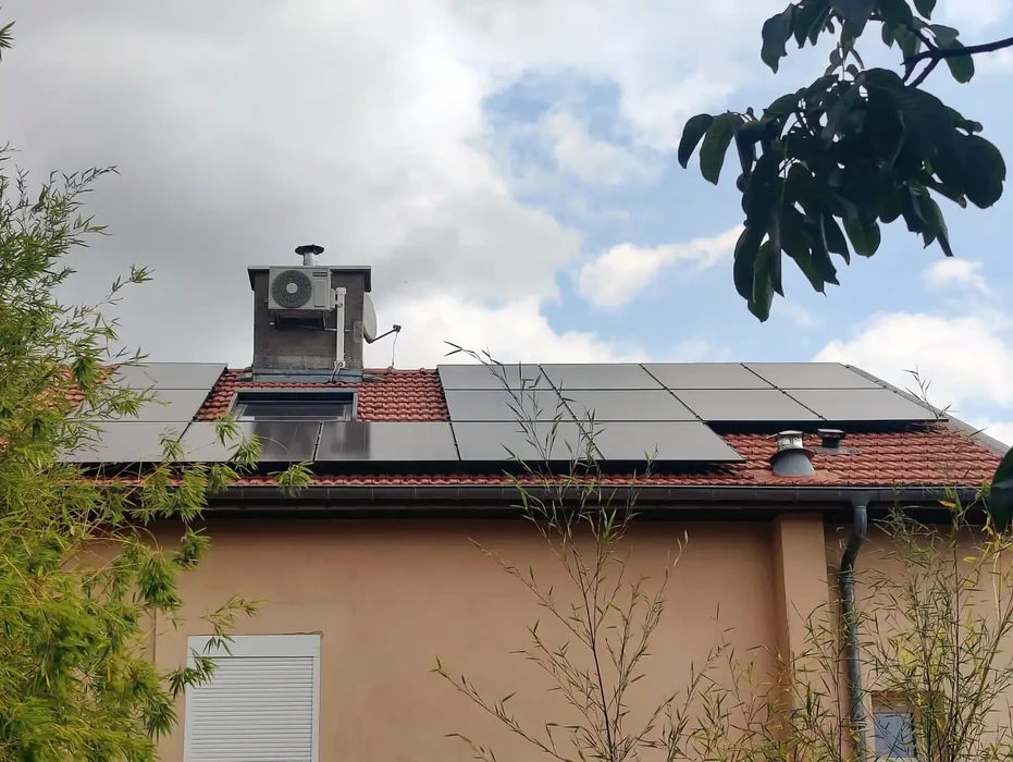 Maison résidentielle avec installation de panneaux solaires photovoltaïques sur toiture en tuiles rouges