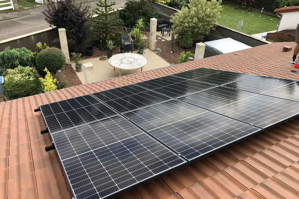 Extérieur résidentiel avec installation de panneaux solaires photovoltaïques sur toiture en tuiles terre cuite