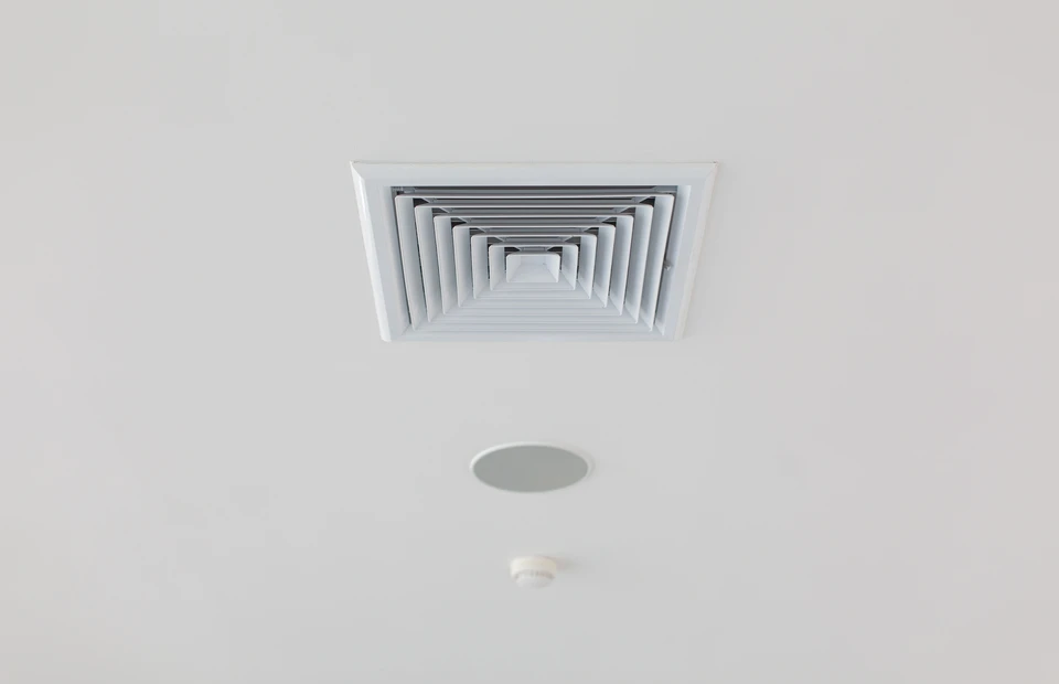 Grille de ventilation à plafond blanc avec diffuseur rectangulaire et prise de fumée