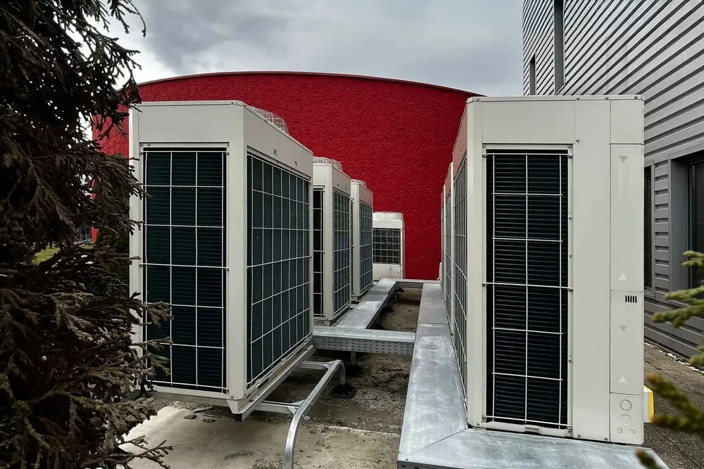Extérieur d'un bâtiment avec unités de climatisation industrielles installées sur une terrasse