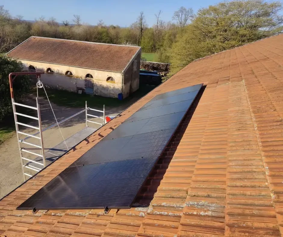 Chantier extérieur d'installation de panneaux solaires photovoltaïques sur toiture en tuiles terre cuite