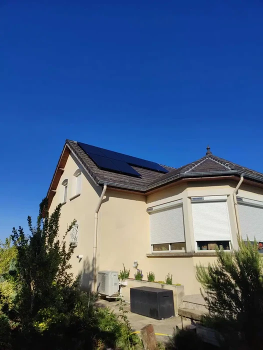 Extérieur résidentiel avec unité de climatisation installée près d'une habitation moderne