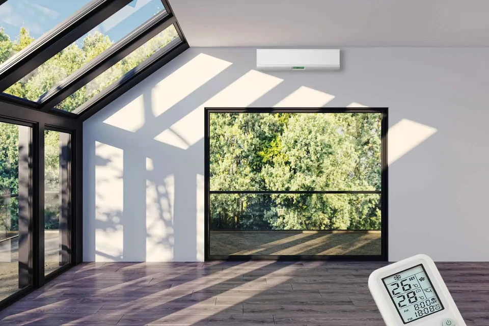 Trois professionnels du bâtiment en casques de sécurité blancs et jaune collaborent autour d'une table de travail dans un espace intérieur moderne